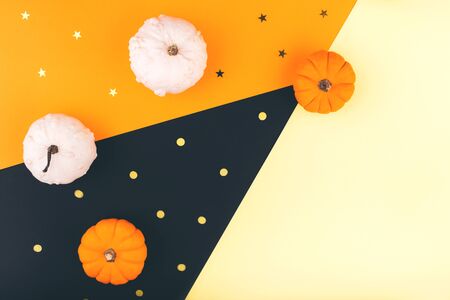 Halloween pumpkins on orange, yellow and black background. Place for design. Flat lay, copy space, top view. Happy Halloween Card.の写真素材
