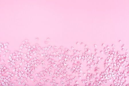 Pink background. Pink hearts on a pink background. Hearts sprinkles. Flat lay style. Top view. Place for design. Sweet background. Confettiの写真素材