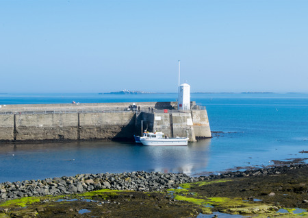 Harbour wall at Sea Houses with tour boatの写真素材