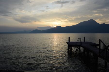 Sunset dropped over the mountain range of Lake Garda, Italyの写真素材