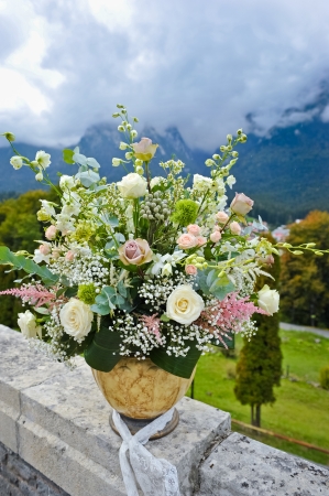large pot with flowers and landscape with mountains behindの写真素材