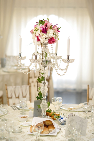 Wedding decoration on table. Floral arrangements and decoration. Arrangement of pink and white flowers in restaurant for luxury wedding eventの写真素材