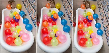 Bunch of colorful balloons in bath tube. Large pile of multicolored inflated balloons.の写真素材