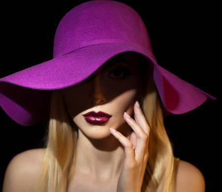 Beautiful woman portrait. Fashion art photo. Beautiful young model with mauve hat on colored background, studio shot. Elegant blonde with makeup. Romantic retro style lady with sensual mouthの写真素材