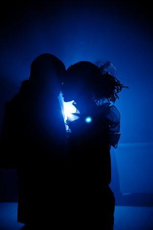 WEDDING COUPLE ON THEIR OPENING DANCE IN HAZE LIGHT WITH BLUE FLASH BACKLIGHTの写真素材