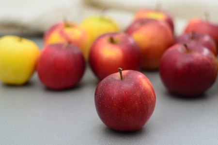Red and yellow apples on the gray tabletopの写真素材