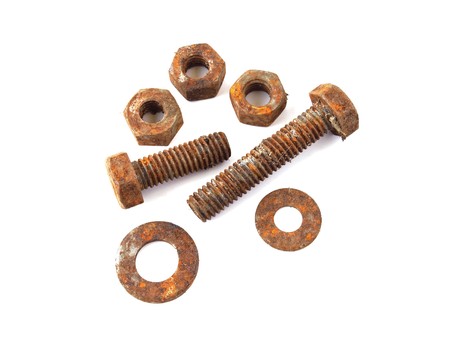 Rusty nuts and bolts on a plane white background.の写真素材