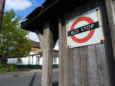 Old fashioned wooden bus shelter in Ifield Green Crawley with Public House in backgroundの写真素材