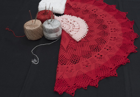 Crochet, Italian manufacture. made in Italy. Balls of yarn and crochet for the work of the school of Italian craftsmanship. black background. Examples of complex jobs. Excellent execution.の写真素材