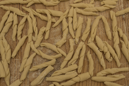 Fusilli pasta with homemade Italian soft wheat flour type 00, first floor of the dough on the wooden table, stripes and white flour.の写真素材