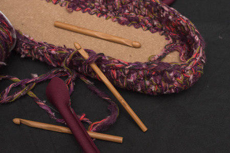 Leather bottom of the first laps of knitted wool with wppden crochet hooks.の写真素材