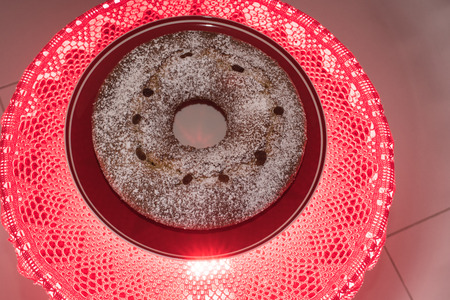 sweet bunwith powdered sugar on red round tableの写真素材