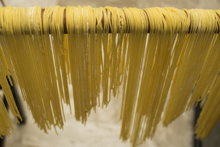 Handmade egg noodles resting on the wooden cutting board or left to dry.の写真素材