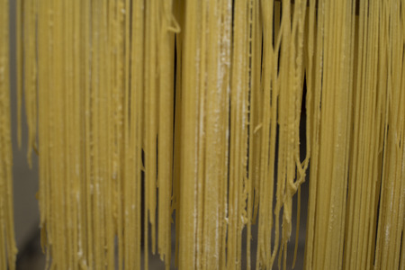 Handmade egg noodles resting on the wooden cutting board or left to dry.の写真素材