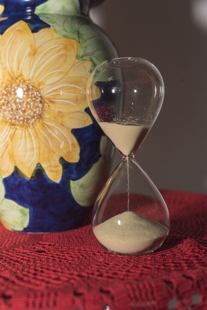 Red tulips in blue vase, with yellow daisy, Vietri Sul Mare ceramic on red crochet doily and...