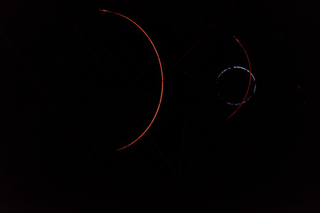 Colored arches intersect in the night, red, yellow, blue, green. Colored trajectories, anomalous...