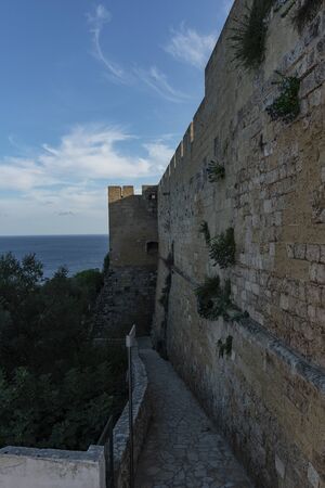 Views of Castro at sunset. Ancient Aragonese walls between blue skies, blue sea and yellow earth. Lecce stone walls and white houses.の写真素材