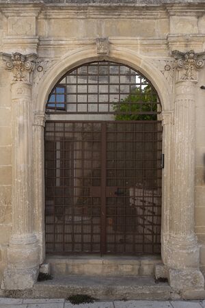 Castrigliano, Puglia, Italy. View of the baroque gate with a wrought iron gate leading to the inner courtyard of the house. Messapia, Greek cities.の写真素材
