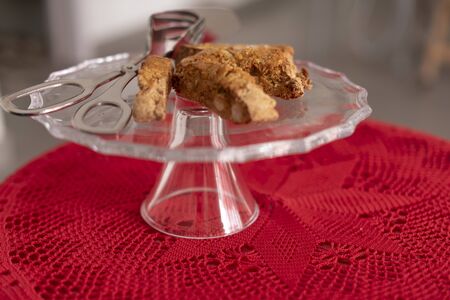 Four Cantucci on glass tray, typical of the Italian tradition. Red crochet tablecloth. Ready to be served.の写真素材