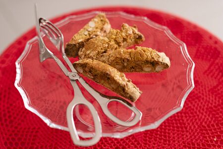 Four Cantucci on glass tray, typical of the Italian tradition. Red crochet tablecloth. Ready to be served.の写真素材
