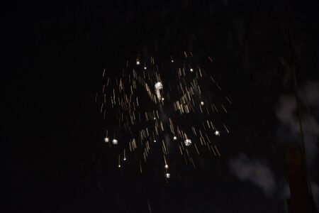Fire stars, plays of light, clouds of smoke in the black sky of a summer night.の写真素材
