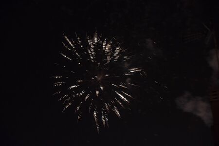 Fire stars, plays of light, clouds of smoke in the black sky of a summer night.の写真素材