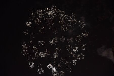 Fire stars, plays of light, clouds of smoke in the black sky of a summer night.の写真素材
