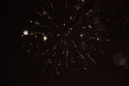 Fire stars, plays of light, clouds of smoke in the black sky of a summer night.の写真素材