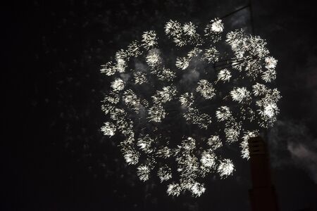 Fire stars, plays of light, clouds of smoke in the black sky of a summer night.の写真素材