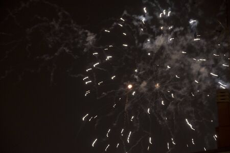 Fire stars, plays of light, clouds of smoke in the black sky of a summer night.の写真素材