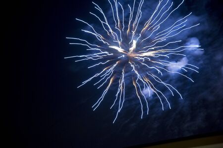 Fire stars, plays of light, clouds of smoke in the black sky of a summer night.の写真素材