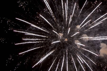 Fire stars, plays of light, clouds of smoke in the black sky of a summer night.の写真素材