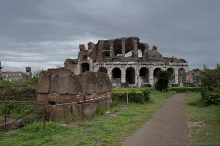 Roman amphitheater. External view of the arena and the ancient ruins. In the background the gray and cloudy sky of a rainy day.の写真素材