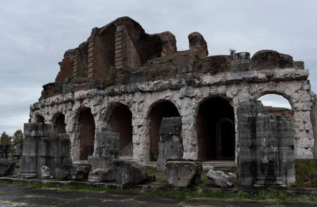 Roman amphitheater. External view of the arena and the ancient ruins. In the background the gray and cloudy sky of a rainy day.の写真素材