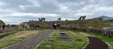 Roman amphitheater. External view of the arena and the ancient ruins. In the background the gray and cloudy sky of a rainy day.の写真素材