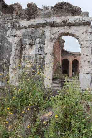 Roman amphitheater. External view of the arena and the ancient ruins. In the background the gray and cloudy sky of a rainy day.の写真素材
