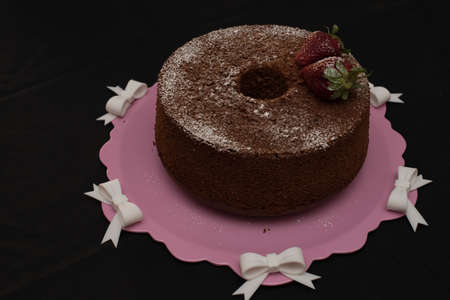 donut strawberry with icing sugar and strawberry on pink and white tablecloth tray.の写真素材