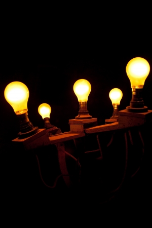 Wooden light fixture holding 5 tungsten light bulbsの写真素材