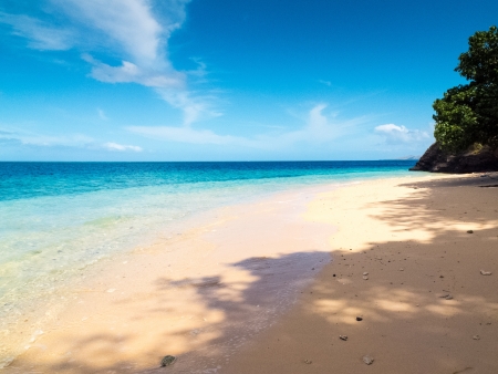 White sand beach with crystal clear blue water in the tropicsの写真素材