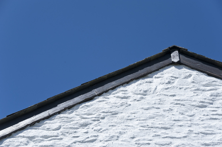 white gable wall and roof against a blue sky