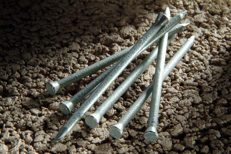 Masonry Nails on concrete block backgroundの写真素材