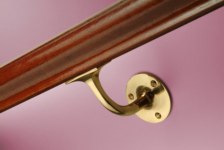Detail of handrail showing brass bracket on violet wallの写真素材