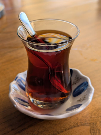 A classic presentation of Turkish tea served in a tulip-shaped glass, symbolizing the warmth and...