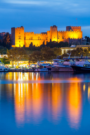 Mandraki Harbour Rhodes Greece and The Palace of the Grand Master of the Knights of Rhodes at night.のeditorial素材