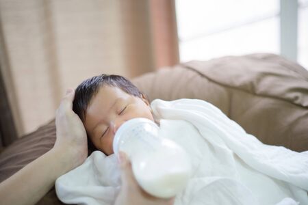 After infant eat breast milk from her mother and the she sleep on the pad bedの写真素材