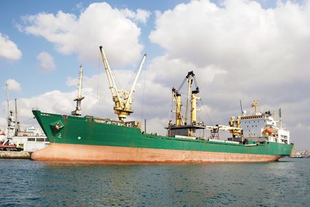 Green bulk carrier ship docked in harbor