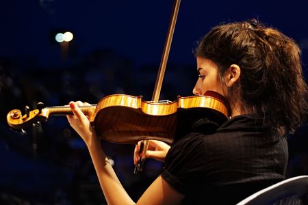 ISTANBUL - JULY 11: Members of the Maltepe Symphonic Orchestra perform live at Maltepe open air stage. Musician playing violin.のeditorial素材