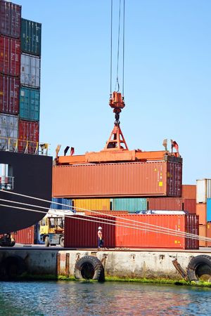 Freight container hanging on crane at sea port