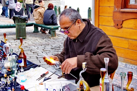 ISTANBUL - MARCH 29: A glassblower demonstrates the art of making glassware at Ortakoy street market on March 29, 2009 in Istanbul. Street peddlers sell various kind of home made items hereのeditorial素材
