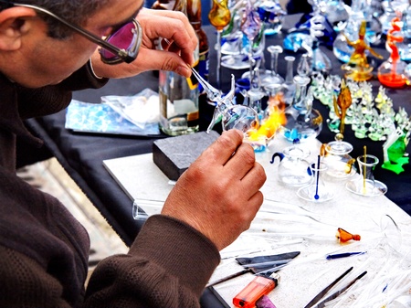 ISTANBUL - MARCH 29: A glassblower demonstrates the art of making glassware at Ortakoy street market on March 29, 2009 in Istanbul. Street peddlers sell various kind of home made items hereのeditorial素材